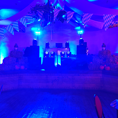 Bühne mit blauer Lichttechnik und bayrischer Deko bei einer Oktoberfest-Kirmes in Meiningen