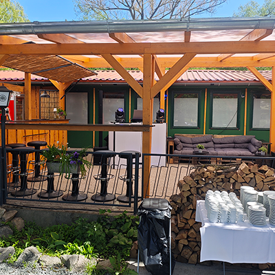 Eine überdachte Holzterrasse mit Barbereich, Palettensofa und weißem DJ-Pult, hergerichtet für den 40. Geburtstag in chilligen in Aussengelände mit DJ Andreas in Bad Frankenhausen.