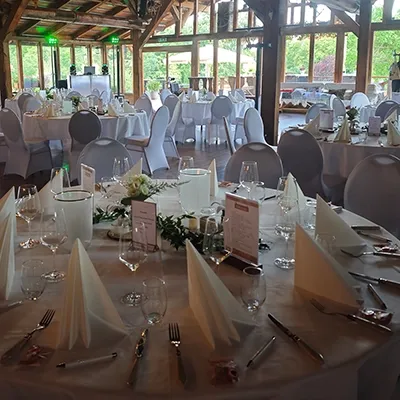 Festlich gedeckte runde Tische und beleuchteter Technikaufbau für eine Hochzeit auf einer Landalm mit Hochzeits-DJ Stadtilm